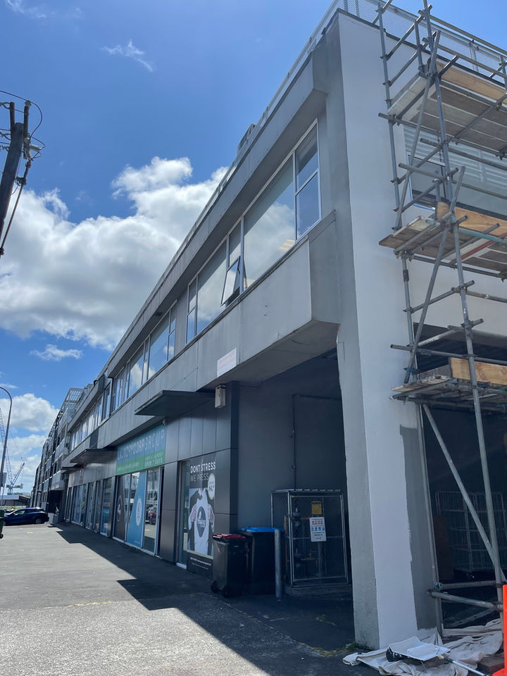 Multi-unit building exterior during repainting with scaffolding