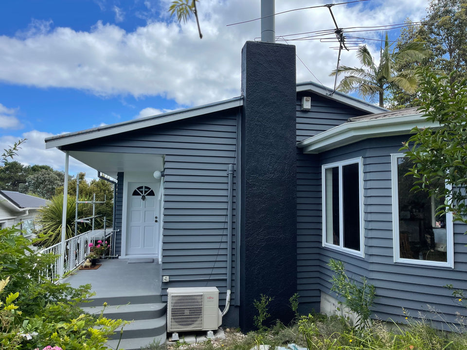 Charcoal-painted weatherboard Auckland house with crisp white trim
