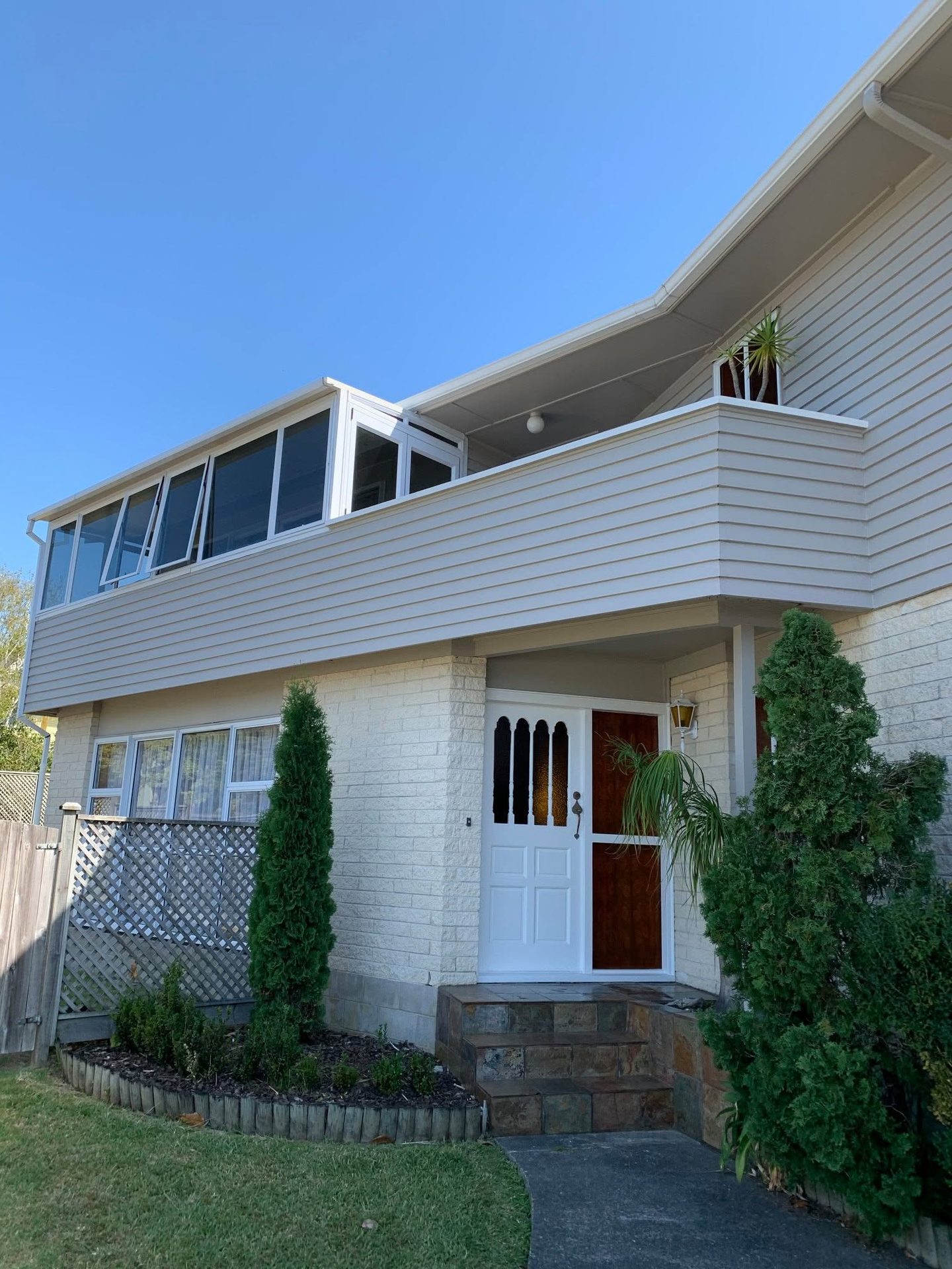 Two-storey white weatherboard home after painting